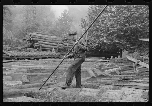 Untitled photo, possibly related to: Men spiking logs to go up ramp into sawmill. It was working only halftime and was even slower in winter.  "It's kinder hard them times. Concrete and steel's taking the place of lumber nowadays. Erwin, West Virginia