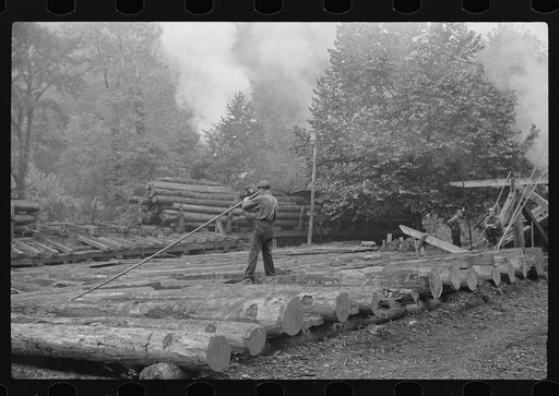 Untitled photo, possibly related to: Men spiking logs to go up ramp into sawmill. It was working only halftime and was even slower in winter.  "It's kinder hard them times. Concrete and steel's taking the place of lumber nowadays. Erwin, West Virginia