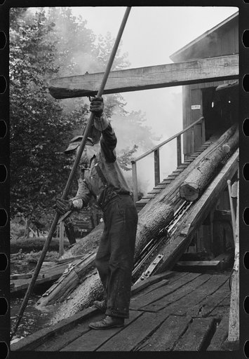 Untitled photo, possibly related to: Spiking and guiding logs up ramp into mill where they are sawed. Erwin, West Virginia