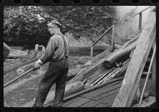 Untitled photo, possibly related to: Spiking and guiding logs up ramp into mill where they are sawed. Erwin, West Virginia