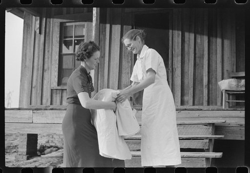 Miss Hesterley, FSA (Farm Security Administration) supervisor, delivers sheeting to Mrs. A.L. Lanier on undeveloped government place. Coffee County, Alabama