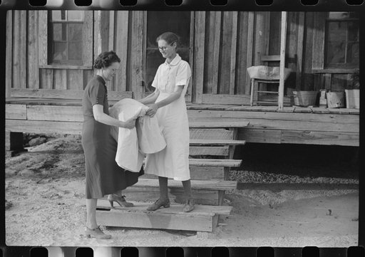 Untitled photo, possibly related to: Miss Hesterley, FSA (Farm Security Administration) supervisor, delivers sheeting to Mrs. A.L. Lanier on undeveloped government place. Coffee County, Alabama