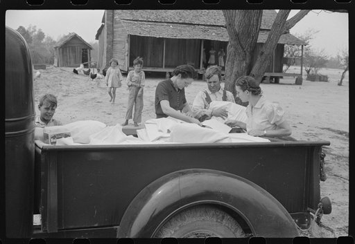 Miss Hesterley and Miss Christian, FSA (Farm Security Administration) home economists, delivering sheeting to Mr. Adkins, rural rehabilitation borrower. This is their first year on the program. There are nine in the family. Coffee County, Alabama
