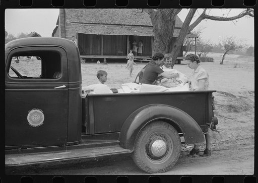 Untitled photo, possibly related to: Miss Hesterley and Miss Christian, FSA (Farm Security Administration) home economists, delivering sheeting to Mr. Adkins, rural rehabilitation borrower. This is their first year on the program. There are nine in the family. Coffee County, Alabama
