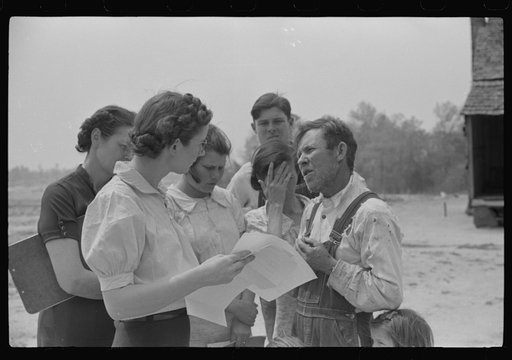 Miss Hesterley and Miss Christian, FSA (Farm Security Administration) home economists, discussing farm and home plan with Ellis Adkins family, rural rehabilitation borrowers, in front of their home. This is their first year on the program. There are nine in the family. Coffee County, Alabama