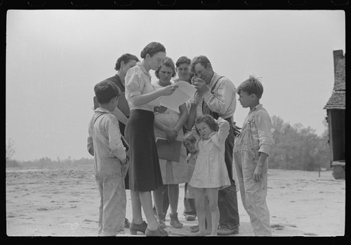 Untitled photo, possibly related to: Miss Hesterley and Miss Christian, FSA (Farm Security Administration) home economists, discussing farm and home plan with Ellis Adkins family, rural rehabilitation borrowers, in front of their home. This is their first year on the program. There are nine in the f