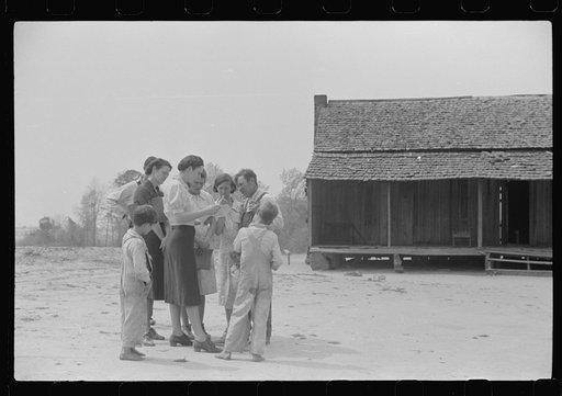 Untitled photo, possibly related to: Miss Hesterley and Miss Christian, FSA (Farm Security Administration) home economists, discussing farm and home plan with Ellis Adkins family, rural rehabilitation borrowers, in front of their home. This is their first year on the program. There are nine in the f