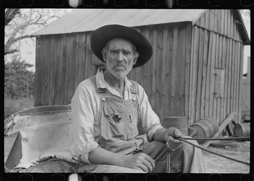 Lee Betties, rural rehabilitation client, with sack of horse and mule feed on rear of his wagon, leaving general store at Woodville, Greene County, Georgia