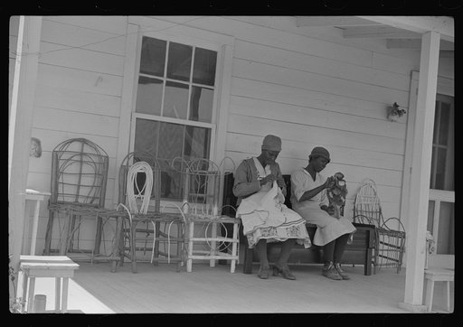 Jorena Pettway and her daughter making chair cover out of bleached flour sacks and flower decorations from paper. She also made the chairs and practically all the furniture in the house. Gees Bend, Alabama