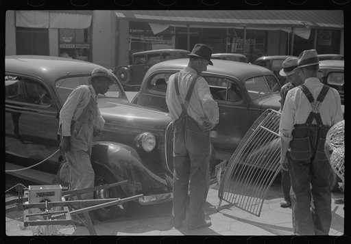Hardware and farmers' supply store, Greensboro, Georgia. Farmers examining implement on sidewalk in front of store