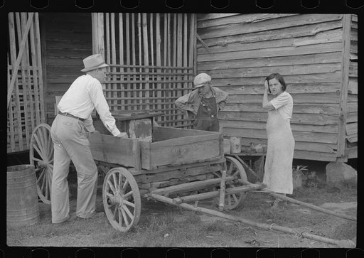 FSA (Farm Security Administration) supervisors talking with rehabilitation borrowers about the old stove that has just been replaced in their house with a new one. Greene County, Georgia