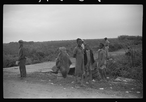 Vegetable pickers, migrants, waiting after work to be paid. Near Homestead, Florida