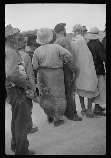 Homestead (vicinity), Florida. Migrant vegetable pickers waiting after work for their pay