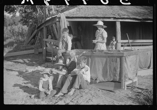 Children of sharecropper sitting near tobacco shed, outside house, near Manning, South Carolina