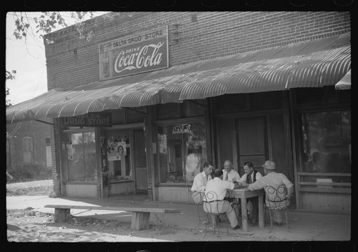 Untitled photo, possibly related to: Playing dominoes or cards in front of drug store in center of town, in Mississippi Delta, Mississippi