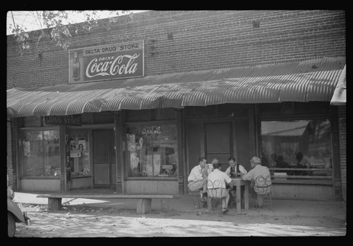 Untitled photo, possibly related to: Playing dominoes or cards in front of drug store in center of town, in Mississippi Delta, Mississippi