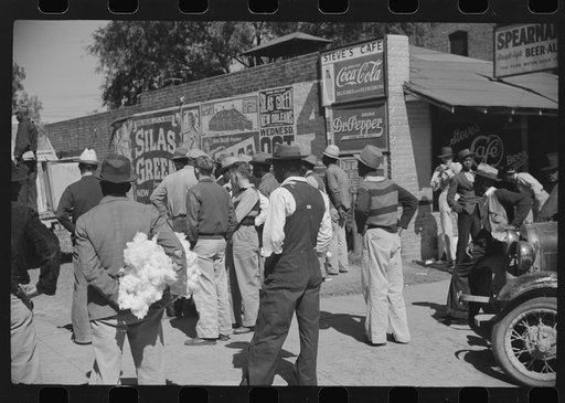 Some of the Negroes watching itinerant salesman selling goods from his truck in center of town. On Saturday afternoon. Belzoni, Mississippi Delta, Mississippi