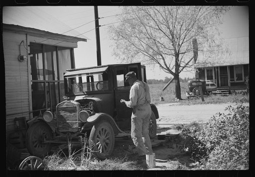 Uncle George who has worked on Marcella Plantation in blacksmith and carpentry shop for last fifty years after he got out of prison, fixing his old car, Mileston, Mississippi Delta, Mississippi