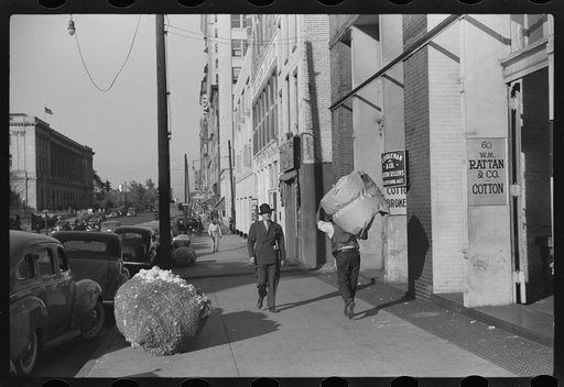 Cotton "snake," waste cotton on sidewalk and cotton samples being carried to sampling and classing rooms in broker's office on Cotton Row, Front Street, Memphis, Tennessee