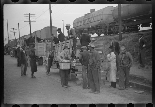Day laborers being hired for cotton picking on Mississippi and Arkansas plantations. Between four and six-thirty every morning during the season, near the Hallan Bridge in Memphis, Tennessee, crowds of Negroes in the streets gather and are loaded into trucks by drivers who bid, and offer them anywhe