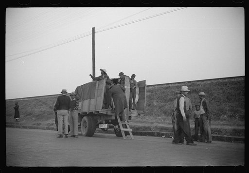 Untitled photo, possibly related to: Day laborers being hired for cotton picking on Mississippi and Arkansas plantations. Between four and six-thirty every morning during the season, near the Hallan Bridge in Memphis, Tennessee, crowds of Negroes in the streets gather and are loaded into trucks by d