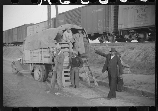 Day laborers being hired for cotton picking on Mississippi and Arkansas plantations. Between four and six-thirty every morning during the season, near the Hallan Bridge in Memphis, Tennessee, crowds of Negroes in the streets gather and are loaded into trucks by drivers who bid, and offer them anywhe