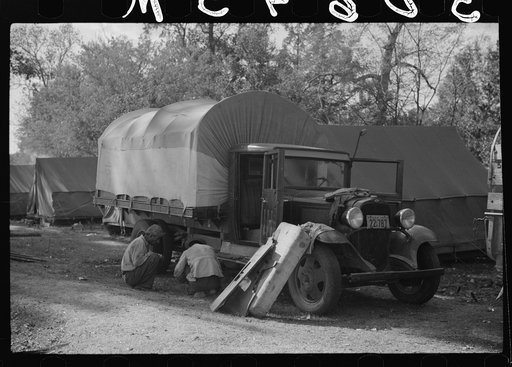 Fixing truck in front of tents of Mexican labor brought from Texas by contractor for the duration of cotton picking season. Hopson Plantation, near Clarksdale, Mississippi Delta, Mississippi