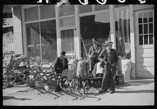 Untitled photo, possibly related to: Farmers waiting around in front of farmer's supply company next to tobacco warehouse during auction sales, Durham, North Carolina