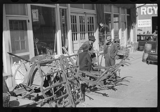 Untitled photo, possibly related to: Farmers waiting around in front of farmer's supply company next to tobacco warehouse during auction sales, Durham, North Carolina