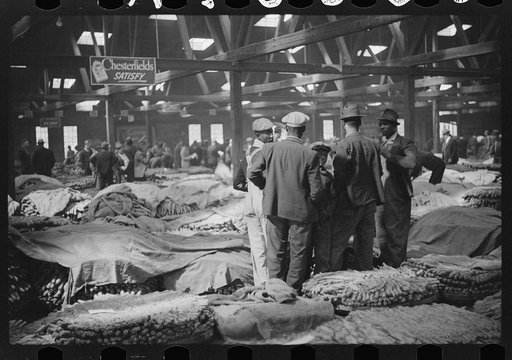 Farmers waiting for tobacco to be sold at auction in warehouse. Durham, North Carolina