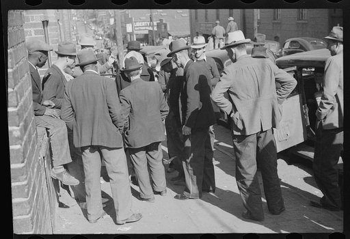 Untitled photo, possibly related to: Farmer selling hound dogs outside tobacco warehouse during auction sales, Durham, North Carolina