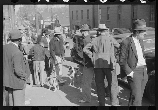 Untitled photo, possibly related to: Farmer selling hound dogs outside tobacco warehouse during auction sales, Durham, North Carolina