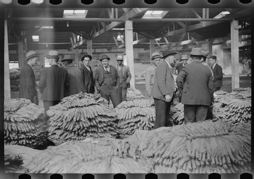 Untitled photo, possibly related to: After the sale at auction the tobacco is piled up in baskets and wheeled to the trucks for loading. Durham, North Carolina