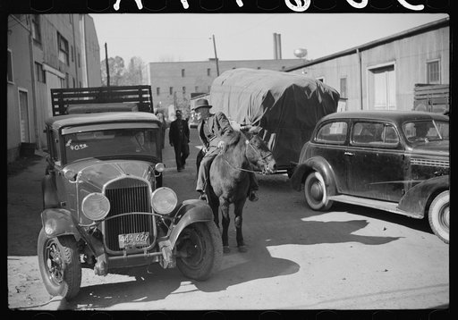 Discussion between farmers waiting outside warehouse during auction sales of tobacco. Durham, North Carolina