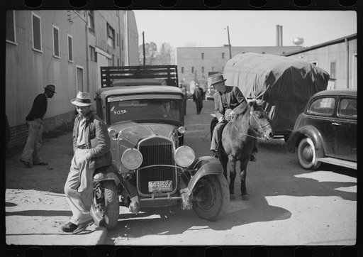 Untitled photo, possibly related to: Discussion between farmers waiting outside warehouse during auction sales of tobacco. Durham, North Carolina