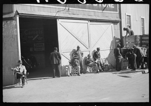 Untitled photo, possibly related to: Farmers waiting and buying apples outside warehouse during tobacco auctions. Durham, North Carolina
