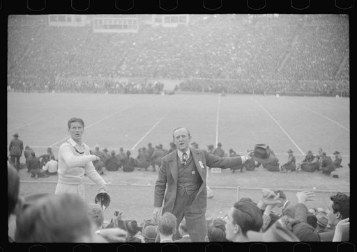 Kay Kyser and cheerleader cheering for North Carolina team at Duke University-North Carolina football game. Durham, North Carolina
