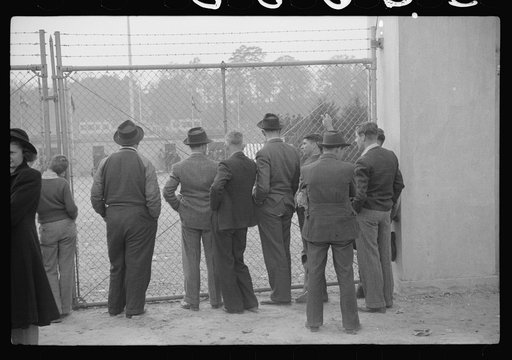 Untitled photo, possibly related to: Spectators standing outside the gate of the Duke University Stadium because there were no more seating accomodations. Duke University-North Carolina game. Durham, North Carolina