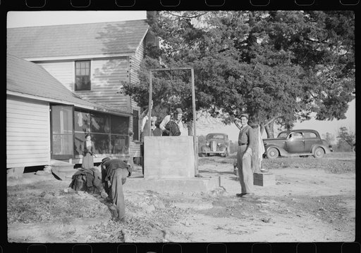 Untitled photo, possibly related to: Men drinking from well on farm near the Fred Wilkins place. They have been shucking corn. Granville County, North Carolina
