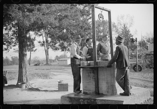 Untitled photo, possibly related to: Men drinking from well on farm near the Fred Wilkins place. They have been shucking corn. Granville County, North Carolina