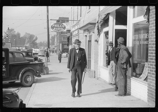 Untitled photo, possibly related to: R.B. Whitley, who is president of the bank and one of the leading citizens of the town, walking down the steet of Wendell, Wake County, North Carolina. He practically owns and runs the town