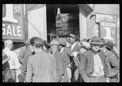 Untitled photo, possibly related to: Patent medicine salesman talking to farmers outside warehouse during tobacco auction sales. Durham, North Carolina