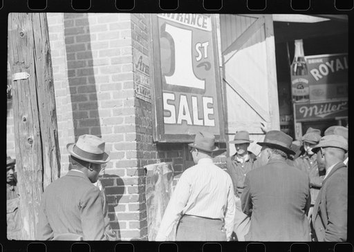 Untitled photo, possibly related to: Patent medicine salesman talking to farmers outside warehouse during tobacco auction sales. Durham, North Carolina