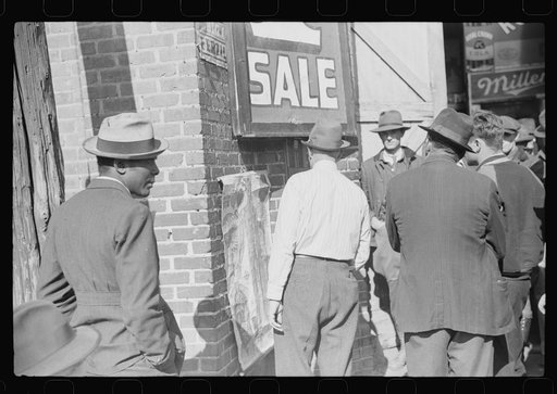 Untitled photo, possibly related to: Patent medicine salesman talking to farmers outside warehouse during tobacco auction sales. Durham, North Carolina