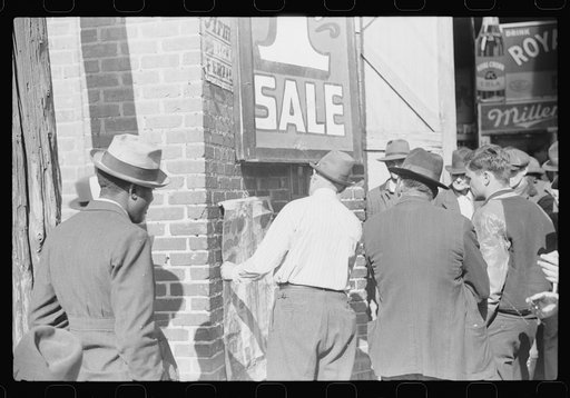 Patent medicine salesman demonstrating his wares to farmers outside warehouse during tobacco auction sales. Durham, North Carolina