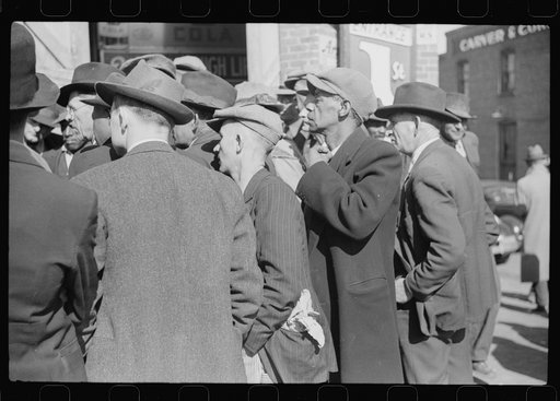 Untitled photo, possibly related to: Patent medicine salesman talking to farmers outside warehouse during tobacco auction sales. Durham, North Carolina
