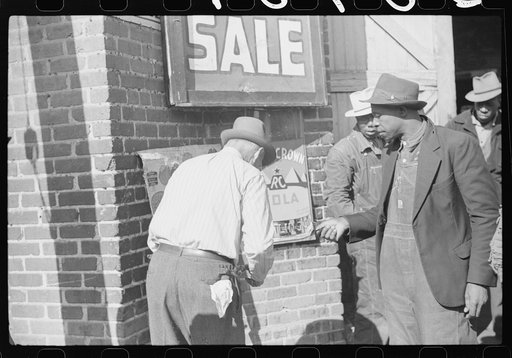Untitled photo, possibly related to: Patent medicine salesman demonstrating his wares to farmers outside warehouse during tobacco auction sale. Durham, North Carolina