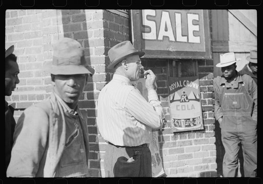 Untitled photo, possibly related to: Patent medicine salesman demonstrating his wares to farmers outside warehouse during tobacco auction sale. Durham, North Carolina