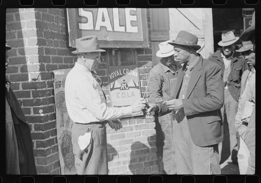 Farmer buying patent medicine from salesman outside tobacco warehouse during auction sale. Durham, North Carolina
