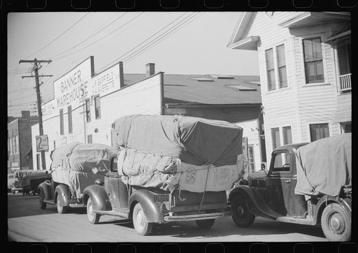 Farmers bringing tobacco to warehouse in trailers, on top of their cars, and even inside their cars for auction. Durham, North Carolina